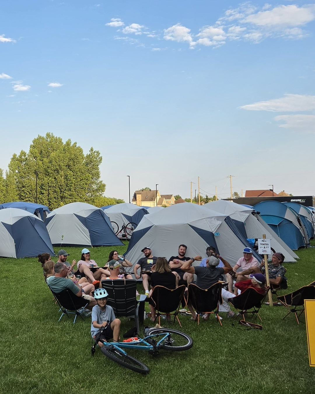 Participants réunis en cercle devant les tentes d'un village Locapaq